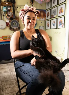 A portrait of Veronique Medrano holding her black cat, showing the personal side of the musician and historian.
