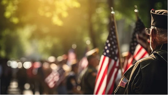 A soldier in uniform holds an American flag during a parade, representing the patriotic service of Texas veterans.